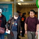 　立法会選挙の投票を終え、火災が起きた高層住宅群近くの投票所を出る有権者ら＝７日、香港（共同）