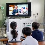 　校内放送でノーベル賞について学ぶ児童たち＝１１日午前、大阪府寝屋川市