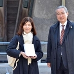 　皇居・東御苑の４千万人目の入園者として宮内庁の古賀浩史管理部長（右）から記念品を受け取った山田裕美子さん＝１１日午後、東京都千代田区