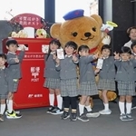 　年賀状の受け付けが始まり、東京中央郵便局の特設ポストに投函する園児たち＝１５日午前、東京・丸の内