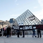 　横断幕を掲げ、ストライキを行うルーブル美術館の職員ら＝１５日、パリ（ロイター＝共同）