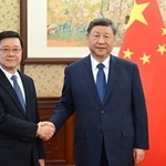 　香港政府トップの李家超行政長官（左）と握手する中国の習近平国家主席＝１６日、北京の中南海（新華社＝共同）