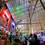 　竹で造られた建物の中で、祭りの展示にカメラを向ける人々＝１８日、香港・新界地区元朗（共同）