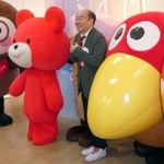 　「お菓子ミュージアム天保山」で、「キョロちゃん」（右）らと記念撮影する吉寿屋の神吉一寿社長＝１９日午前、大阪市港区