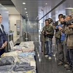 　香港で現金約１０億円が強奪された事件で、押収した服などを撮影する報道陣＝２２日（共同）