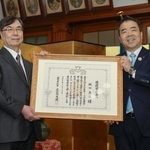 　滋賀県民栄誉賞を受賞し、表彰状を手にする大阪大の坂口志文特任教授。右は三日月大造知事＝２２日午前、県庁