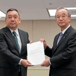 　原子力規制庁の金子修一長官（左）に確認を依頼する文書を手渡す新潟県の花角英世知事＝２３日午前、東京都港区