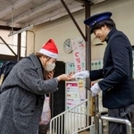 　水間鉄道開業１００周年の記念切符を受け取る乗客（左）＝２４日午前、大阪府貝塚市の貝塚駅