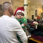 　カトリック教会で開かれたクリスマスの祝祭行事に赤ちゃんを抱いて参列する男性＝２５日、パレスチナ自治区ガザ北部ガザ市（共同）