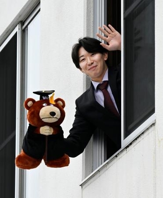 　楽天の寮に入り、自室から手を振る伊藤樹＝５日、仙台市