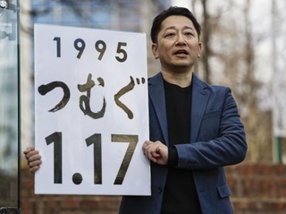 　「１・１７のつどい」の会場に灯籠を並べて作る今年の文字を発表する実行委員会の藤本真一委員長＝９日午後、神戸市中央区の東遊園地