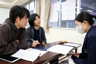 　「石川・能登未来知図」の学習支援活動で、落合梢さん（右）に勉強を教える臼井大地さん（中央）と井上円さん＝２０２５年１２月、石川県珠洲市