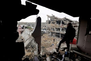 　９日、パレスチナ自治区ガザ中部で、イスラエルの攻撃を受けた建物を調べる人（ロイター＝共同）