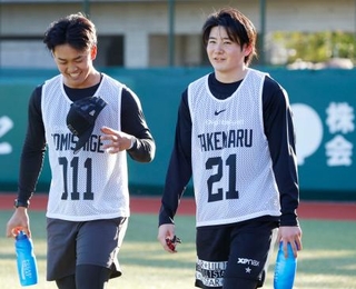 　新人合同自主トレに参加し、笑顔を見せる巨人・竹丸。左は冨重＝ジャイアンツタウンスタジアム