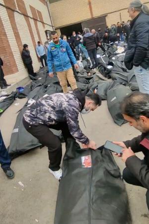 　イラン・テヘラン郊外で９～１１日にかけて撮影された動画の中で、遺体の身元を確認する人々（ソーシャルメディアから、ＡＰ＝共同）