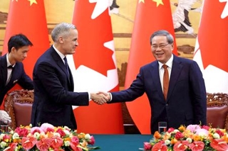 　カナダのカーニー首相（左）と握手する中国の李強首相＝１５日、北京（ロイター＝共同）