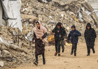 　１８日、ガザ北部ガザ市で、がれきの中を歩くパレスチナ人（ゲッティ＝共同）