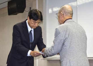 　神戸市立中の男子生徒が自殺した問題で、市教委に報告書を提出する調査委員長（右）＝１９日午後、神戸市