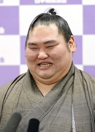 　現役引退の記者会見で笑顔を見せる元幕内の大奄美＝２０日、両国国技館