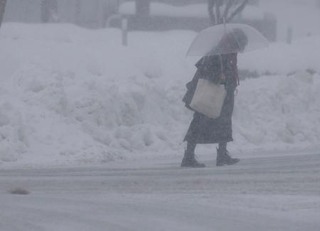 　新潟県長岡市で雪が降る中を歩く人＝２２日午後