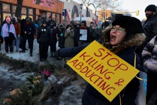 　２４日、米中西部ミネソタ州ミネアポリスで、連邦職員による発砲で男性が死亡した現場に集まった市民ら（ロイター＝共同）