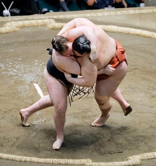 　大相撲初場所千秋楽の優勝決定戦で平幕熱海富士（右）を首投げで破り、２場所連続優勝を果たした大関安青錦＝２５日、東京・両国国技館