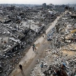 　破壊された住宅のがれきの中を歩くパレスチナ人＝２０２５年１２月３１日、ガザ北部ジャバリヤ（ロイター＝共同）