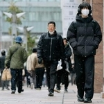 　雪が降る福岡市の繁華街、天神を歩く人たち＝２日午前