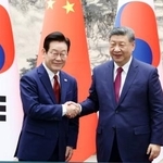 　５日、北京で握手する習近平国家主席（右）と韓国の李在明大統領（聯合＝共同）