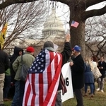 　米議会議事堂前で星条旗を掲げるトランプ大統領の支持者＝６日、ワシントン（共同）