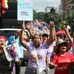 　６日、ベネズエラ・カラカスでプラカードを掲げるマドゥロ大統領の支持者ら（ゲッティ＝共同）