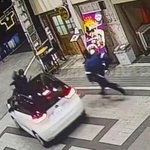 　防犯カメラが捉えた、警察官をボンネットに乗せたまま走行する乗用車の映像＝７日午後、大阪府岸和田市（近隣関係者提供）