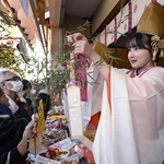 　今宮戎神社で「十日えびす」の幕開けとなる「宵えびす」が始まり、参拝客の福ザサに縁起物を取り付ける福娘＝９日午前、大阪市浪速区