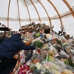 　９日、スイス南部バレー州クランモンタナで、火災の犠牲者を追悼する式典で花を手向ける参列者（ゲッティ＝共同）