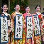 　福島県いわき市の温泉施設スパリゾートハワイアンズで、振り袖姿で書き初めを披露する（左から）ＭＯＭＯＫＡさん、ＭＩＭＩさんら２０歳になるフラガール＝１０日午前