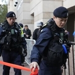 　蘋果日報の創業者、黎智英氏の情状酌量を審理する公判前、裁判所周辺を警戒する警察官＝１２日、香港（共同）