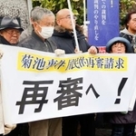 　菊池事件の再審開始を求める署名の提出前、集会を開く支援者ら＝１５日午前、熊本地裁前