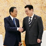 　韓国の李在明大統領（右）と握手を交わす自民党の麻生副総裁＝１６日、韓国大統領府（共同）