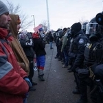 　治安当局の職員らと向かい合うデモ隊＝１７日、米ミネソタ州ミネアポリス（ロイター＝共同）