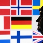 　トランプ米大統領のミニチュア像と、グリーンランドを巡り関税を課すとした対象８カ国の国旗（ロイター＝共同）