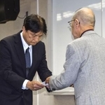 　神戸市立中の男子生徒が自殺した問題で、市教委に報告書を提出する調査委員長（右）＝１９日午後、神戸市