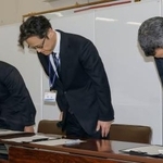 　記者会見で頭を下げる大阪市教育委員会の乗京慎二第３教育ブロック担当部長（中央）ら＝２０日午後、市役所