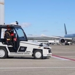 　誘導路手前で自動停止し、航空機の通過を待つ自動運転の貨物けん引車＝２２日午前、中部空港