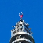 　「台北１０１」を登り切って手を振るオノルドさん＝２５日、台北（中央通信社＝共同）