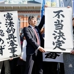 　「菊池事件」の再審開始を認めない熊本地裁の決定を受け、「不当決定」などと書かれた垂れ幕を掲げる弁護士＝２８日午後、熊本地裁前