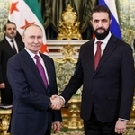 　２８日、モスクワのクレムリンで握手するロシアのプーチン大統領（左）とシリアのシャラア暫定大統領（タス＝共同）