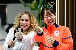 　イタリア・ミラノのマルペンサ空港に到着し、笑顔で取材に応じるスピードスケートの吉田雪乃（右）＝１月３１日（共同）