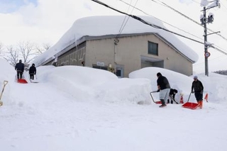 　建物の周囲を除雪する人たち＝２日、青森市