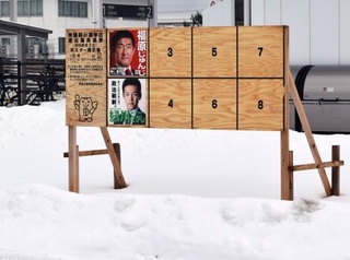 　周囲が雪で覆われた、秋田県男鹿市内の衆院選候補者のポスター掲示板＝４日