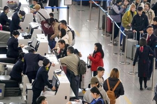 　春節の帰省や旅行に伴う特別輸送態勢「春運」が始まり、北京首都国際空港の日本便を扱うカウンターで搭乗手続きをする人たち＝２日（共同）